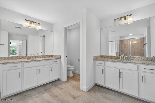 a bathroom with double sink and a mirror