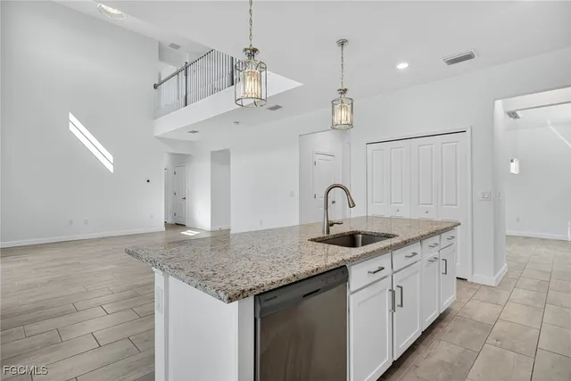 a kitchen with kitchen island granite countertop a sink and refrigerator