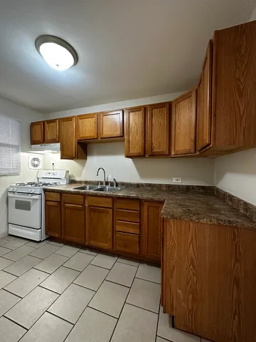 a kitchen with a sink a stove and cabinets