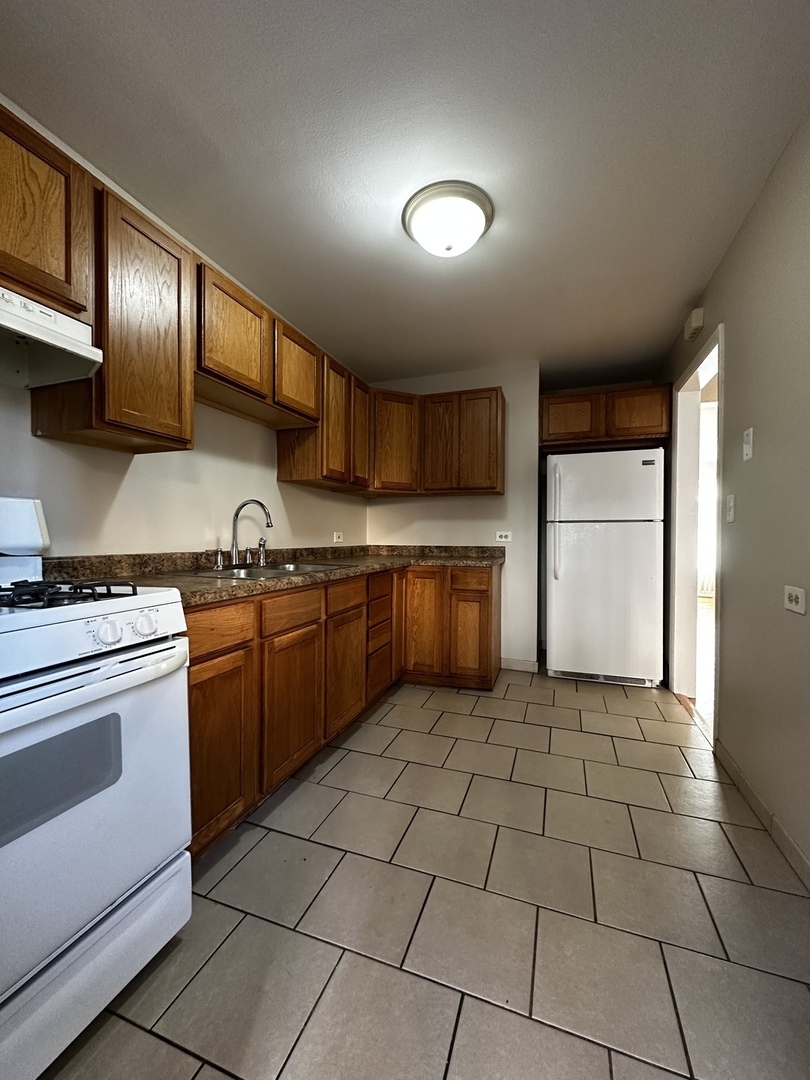 739 Walnut Street, Unit 739 Waukegan, IL 60085 - Photo 3 of 10 a kitchen with stainless steel appliances granite countertop a stove a sink and a refrigerator