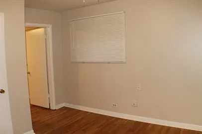 an empty room with wooden floor and closet