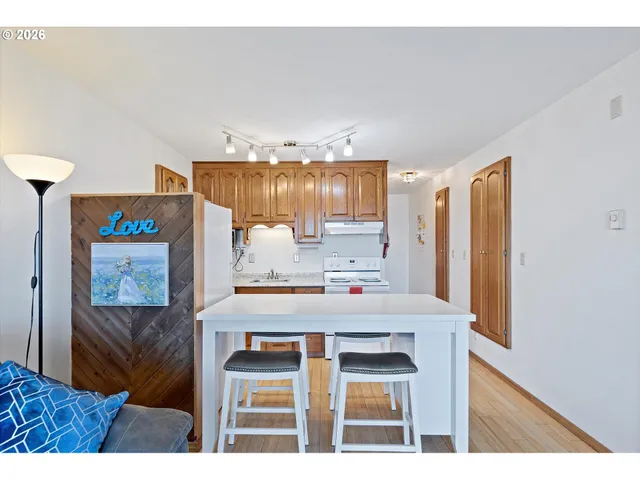 a kitchen with kitchen island a stove a refrigerator a sink a dining table and chairs