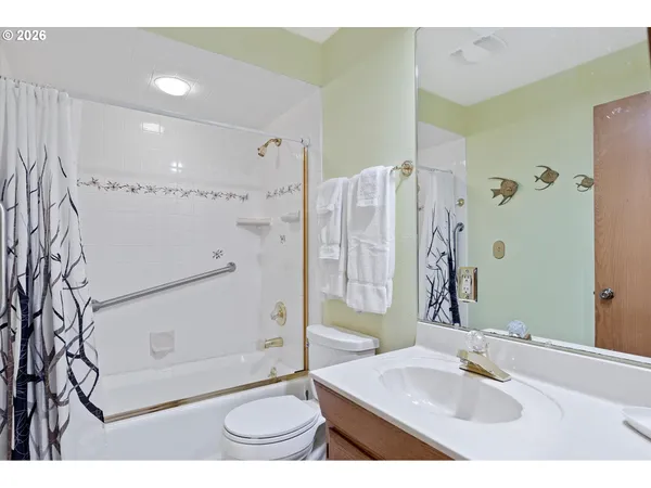 a bathroom with a granite countertop sink a toilet and shower