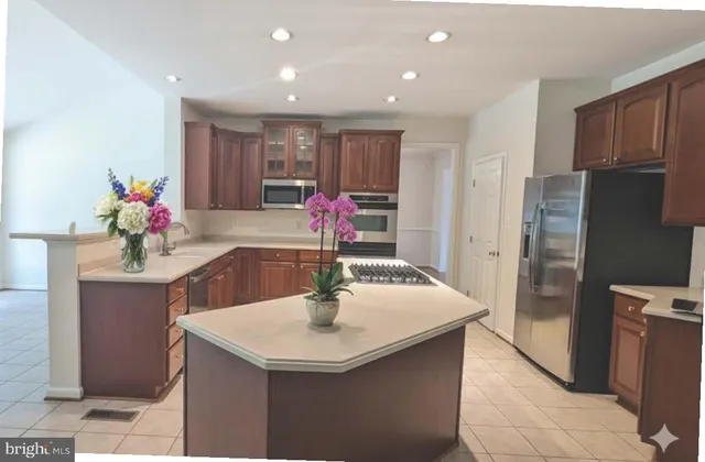 a kitchen with stainless steel appliances granite countertop a sink a stove and a refrigerator