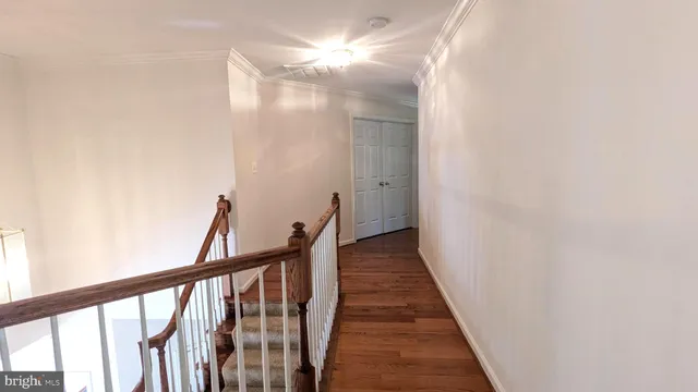 an empty room with a chandelier fan and windows