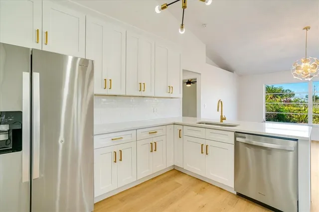 a kitchen with white cabinets and refrigerator