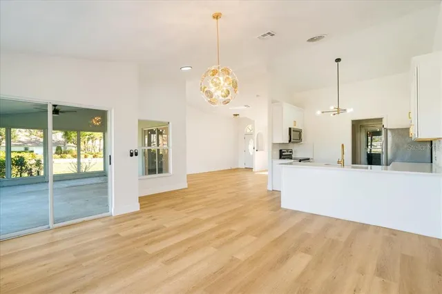 a view of a kitchen with wooden floor and a large window
