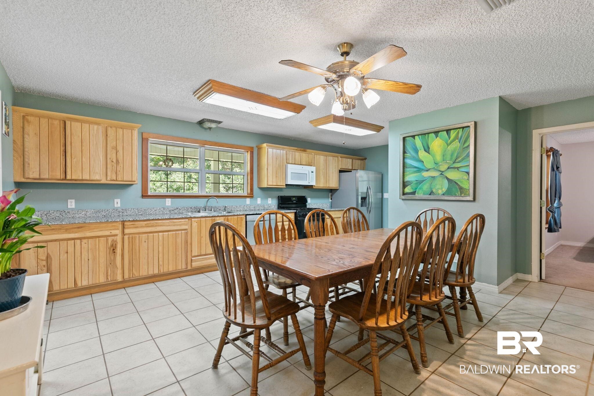 20219 Greek Cemetery Road Robertsdale, AL 36567 - Photo 16 of 41 Kitchen and dining area featuring light wood cabinetry, a stainless steel refrigerator, and black appliances