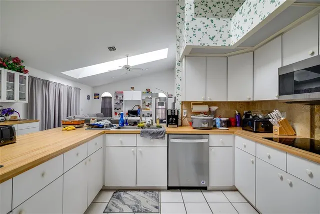a kitchen with stainless steel appliances a sink window and cabinets