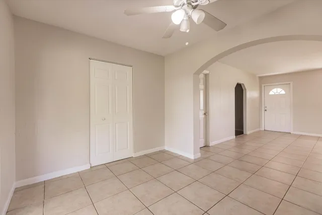 a view of a kitchen with an entryway and a ceiling fan