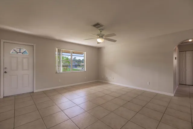 an empty room with windows and fan