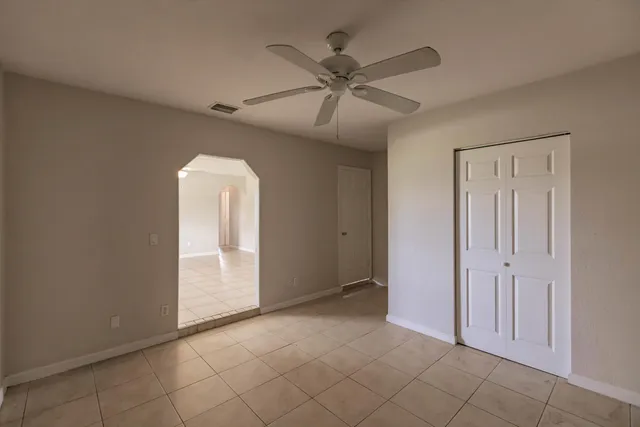 an empty room with fan and windows