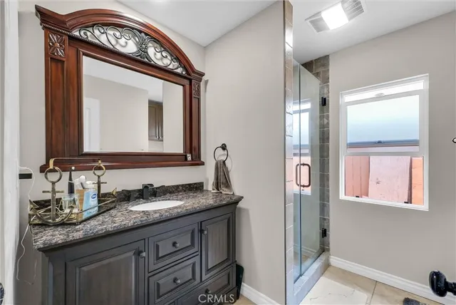 a bathroom with a granite countertop sink a mirror and a window