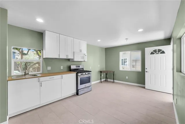 a kitchen with granite countertop a sink and white cabinets