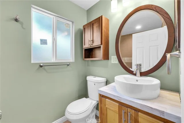 a bathroom with a toilet a sink and a mirror