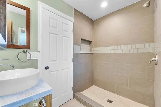 a bathroom with a granite countertop sink a toilet and shower