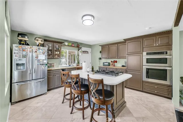 a kitchen with a refrigerator and a stove top oven
