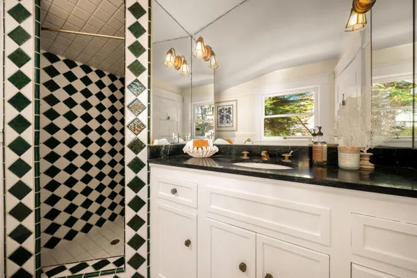 a kitchen with a sink a stove a mirror and shower