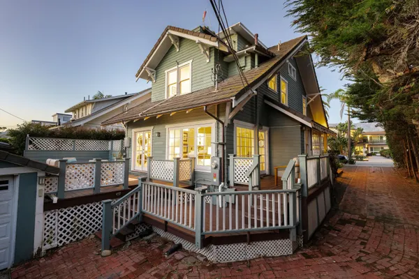 a view of a house with wooden deck and furniture