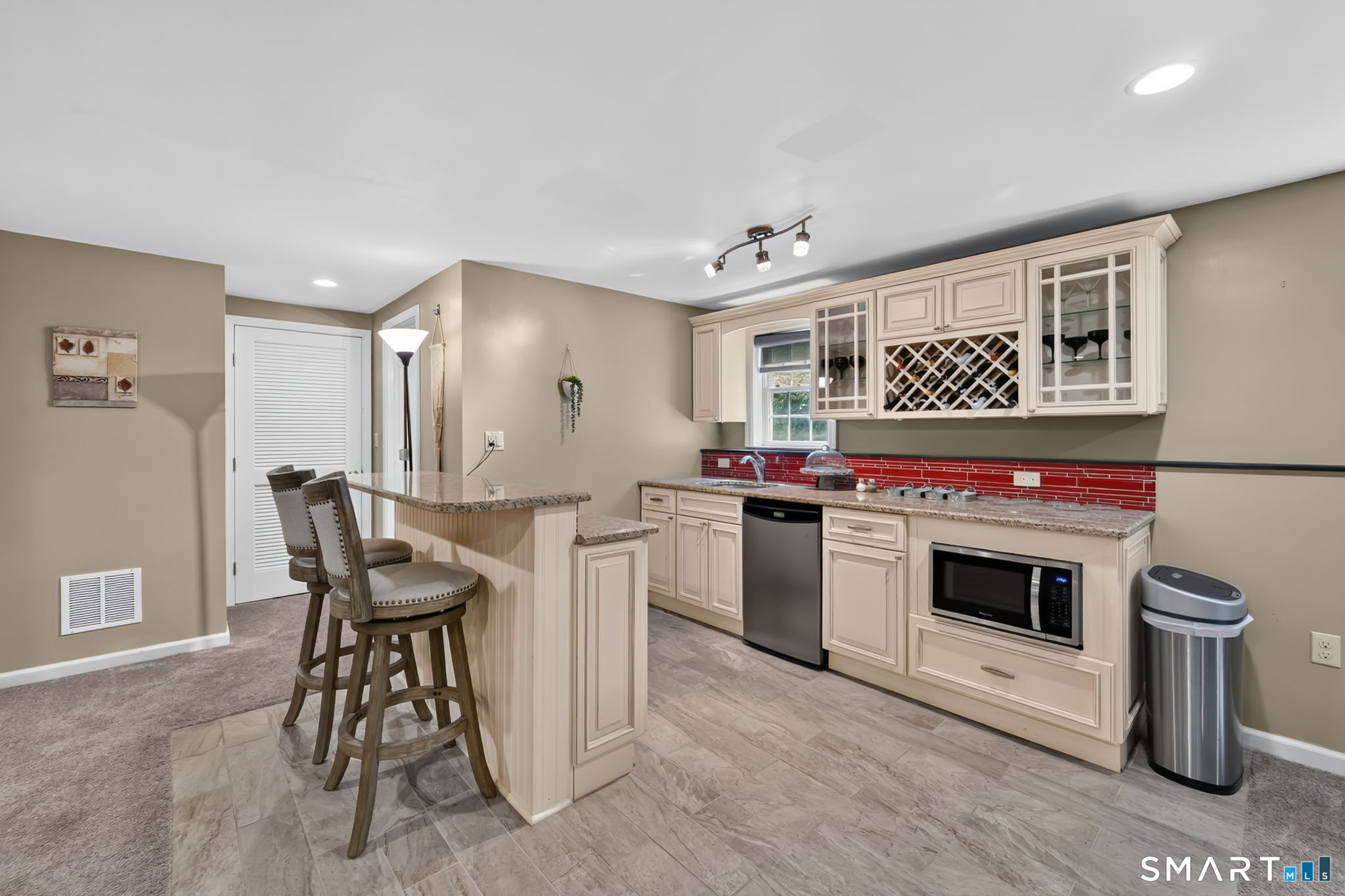 5 Edwards Way Bloomfield, CT 06002 - Photo 31 of 40 Lower level walk out Great Room with kitchenette area and breakfast bar, built-in microwave, dishwasher and refrigerator, granite counters and custom white-stained wood cabinetry.