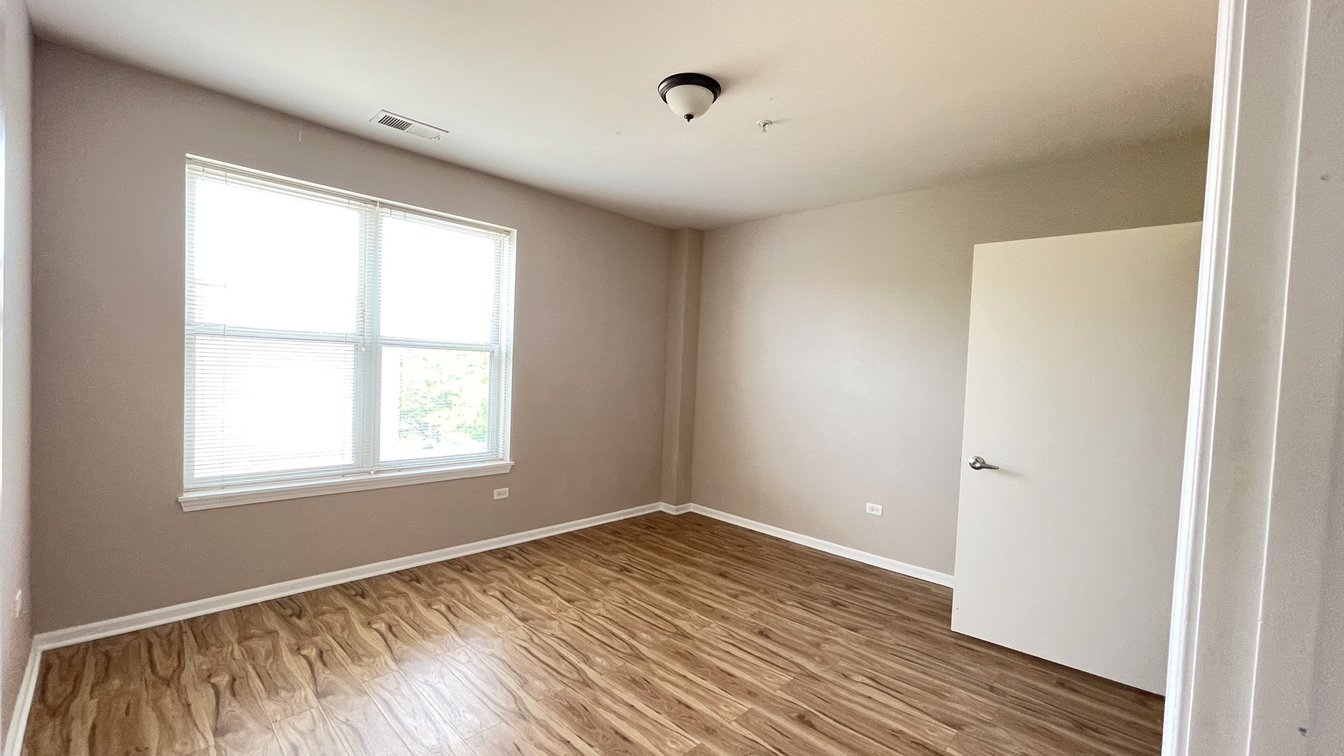 3522 South State Street, Unit 301 Chicago, IL 60609 - Photo 8 of 21 an empty room with wooden floor and windows