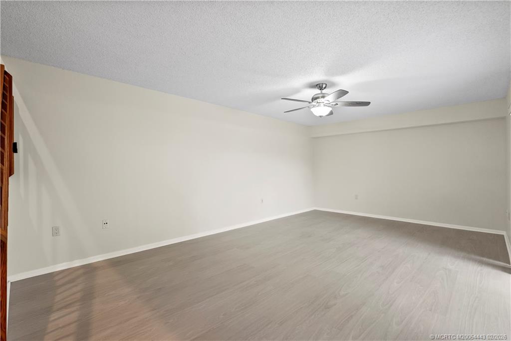 2930 Southwest Sunset Trace Circle Palm City, FL 34990 - Photo 6 of 31 an empty room with a chandelier fan and windows