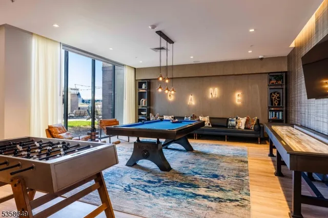 a living room with furniture pool table and flat screen tv