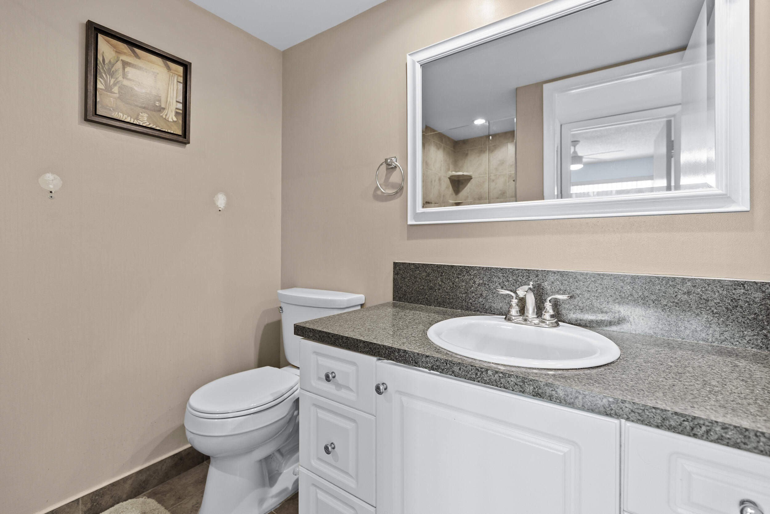 74 Normandy B Delray Beach, FL 33484 - Photo 12 of 21 a bathroom with a granite countertop sink toilet and mirror