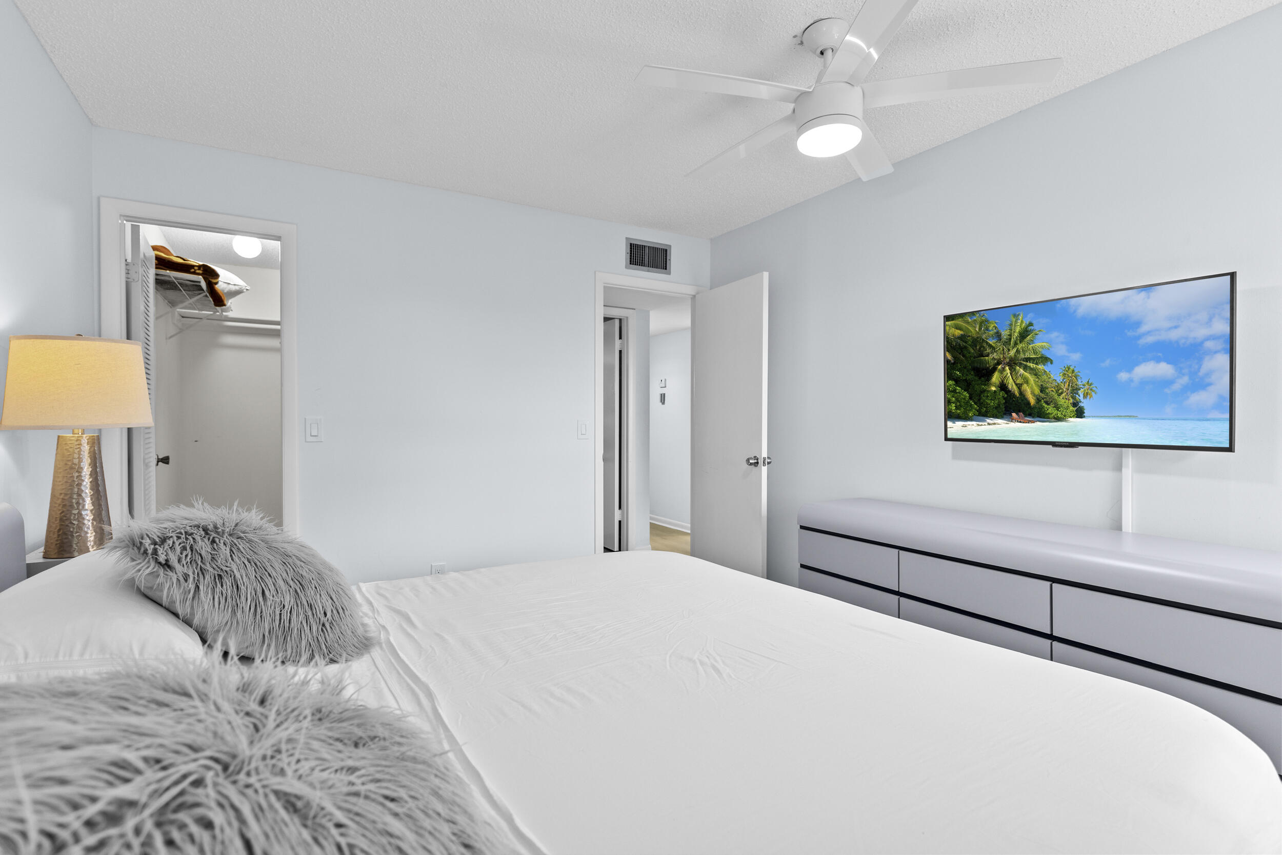 74 Normandy B Delray Beach, FL 33484 - Photo 16 of 21 a bedroom with a bed and a lamp on table