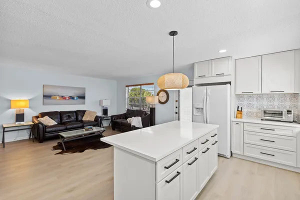 a kitchen with kitchen island a stove a sink and a refrigerator