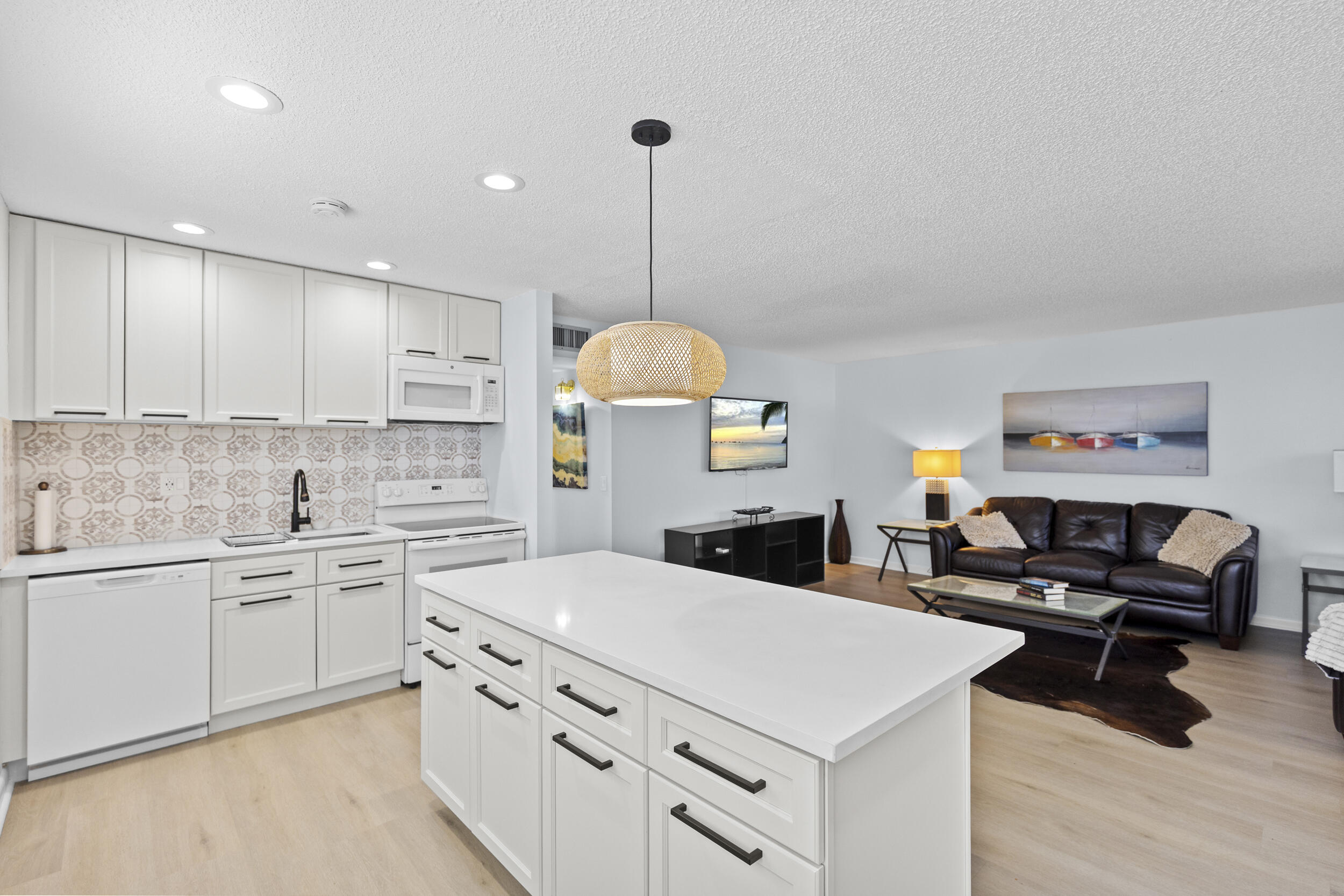 74 Normandy B Delray Beach, FL 33484 - Photo 3 of 21 a kitchen with kitchen island a stove a sink and a refrigerator