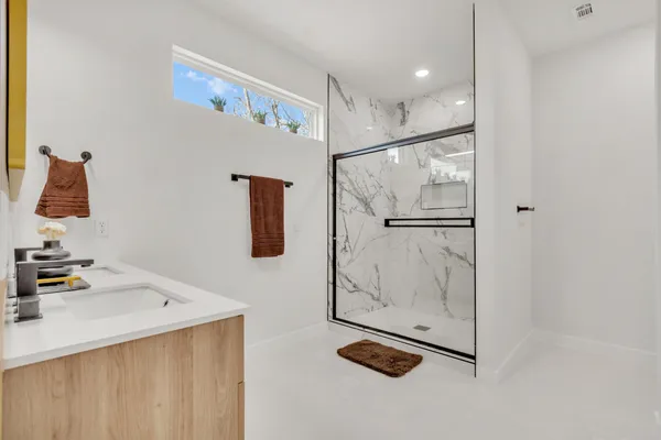 a spacious bathroom with a double vanity sink and mirror