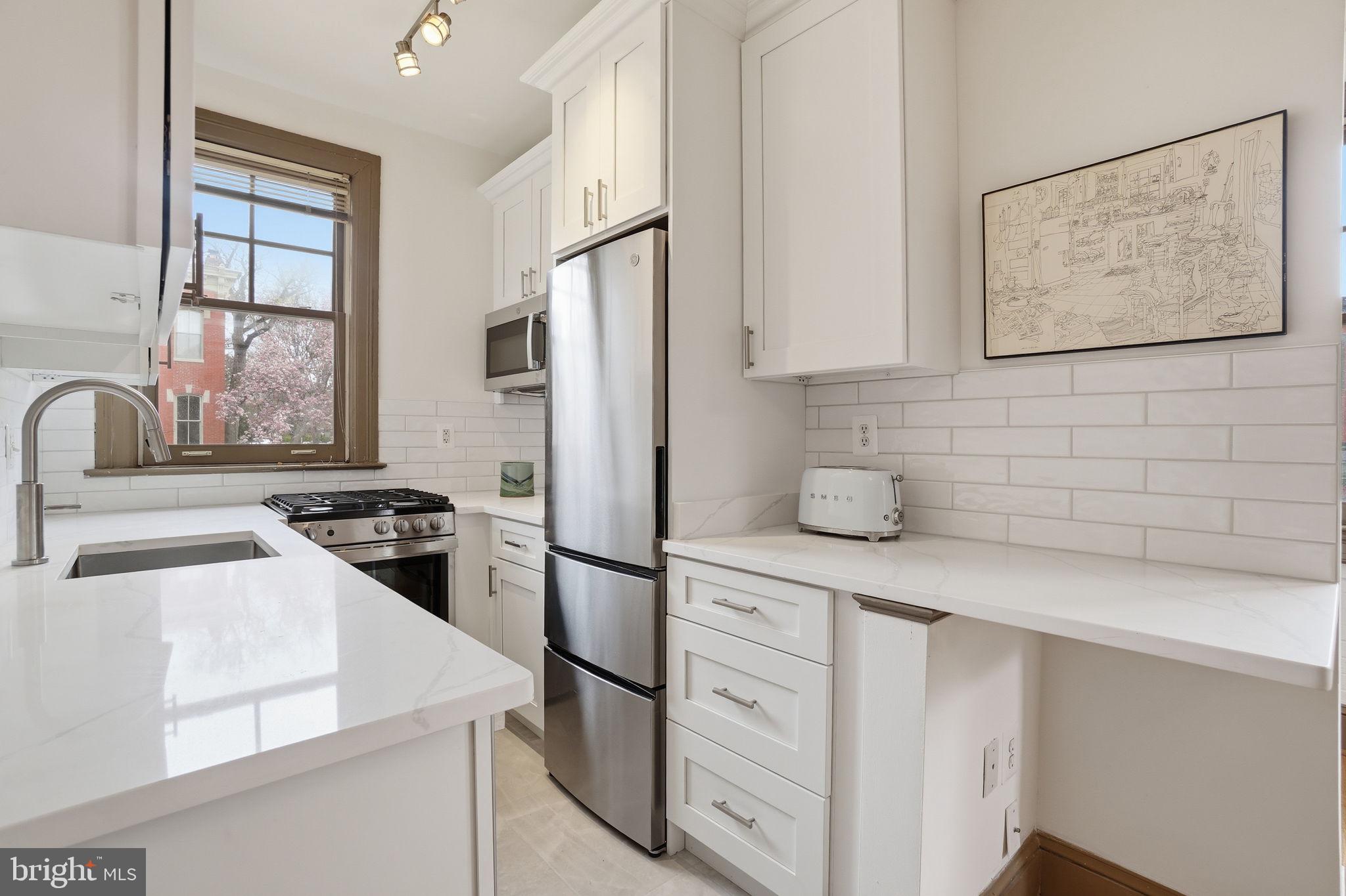 105 6th Street Southeast, Unit 108 Washington, DC 20003 - Photo 11 of 21 a kitchen with stainless steel appliances granite countertop a sink stove and refrigerator