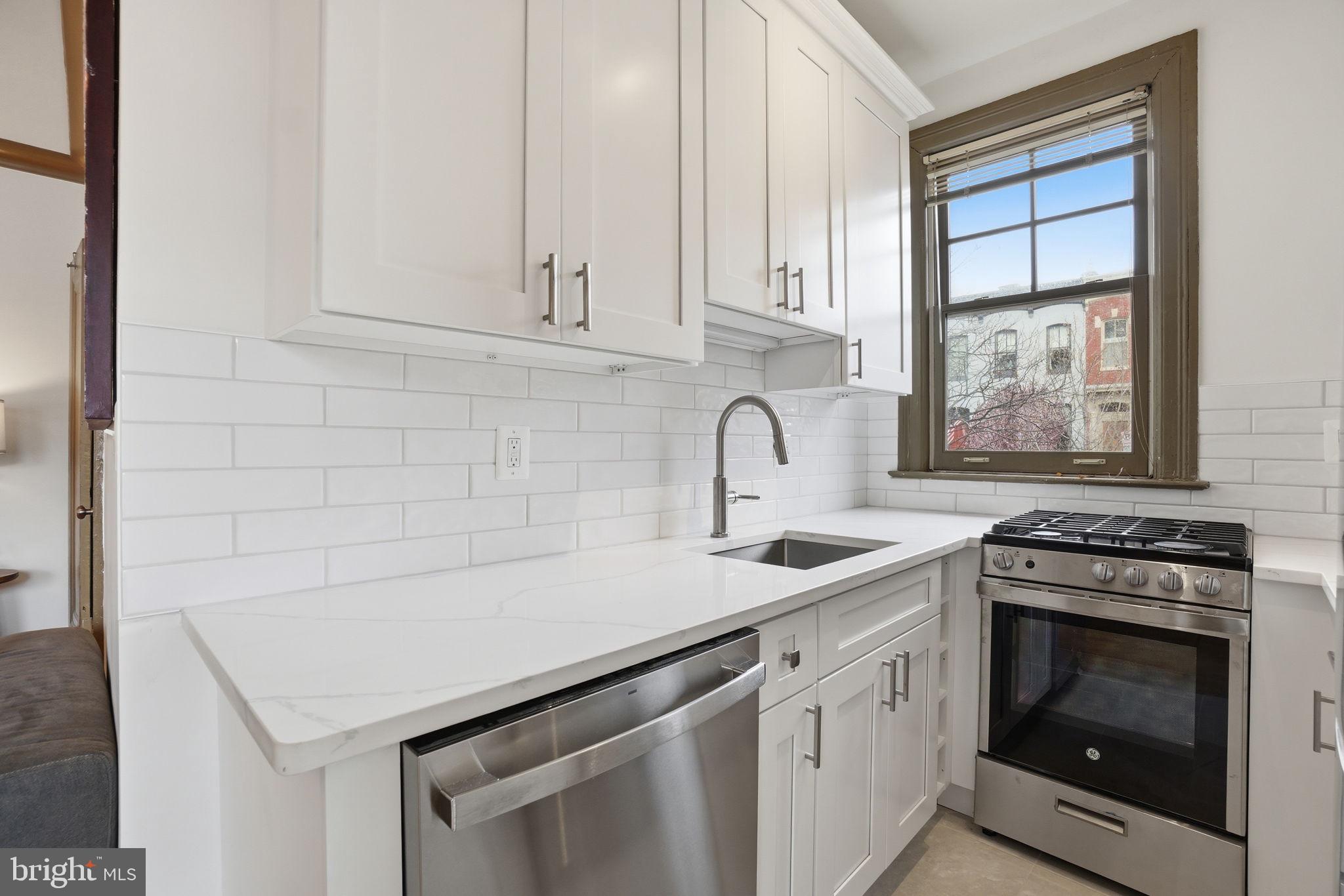 105 6th Street Southeast, Unit 108 Washington, DC 20003 - Photo 12 of 21 a kitchen with white cabinets appliances and sink
