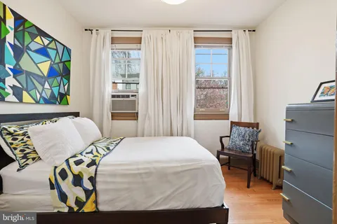 a bedroom with a bed and painting on the wall