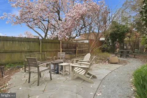a view of backyard with seating space and trees