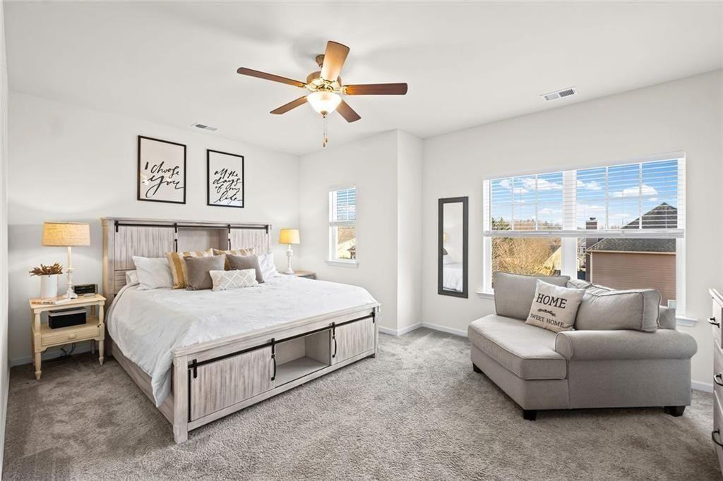 252 Renford Road Ball Ground, GA 30107 - Photo 15 of 36 a bedroom with a bed and a chandelier