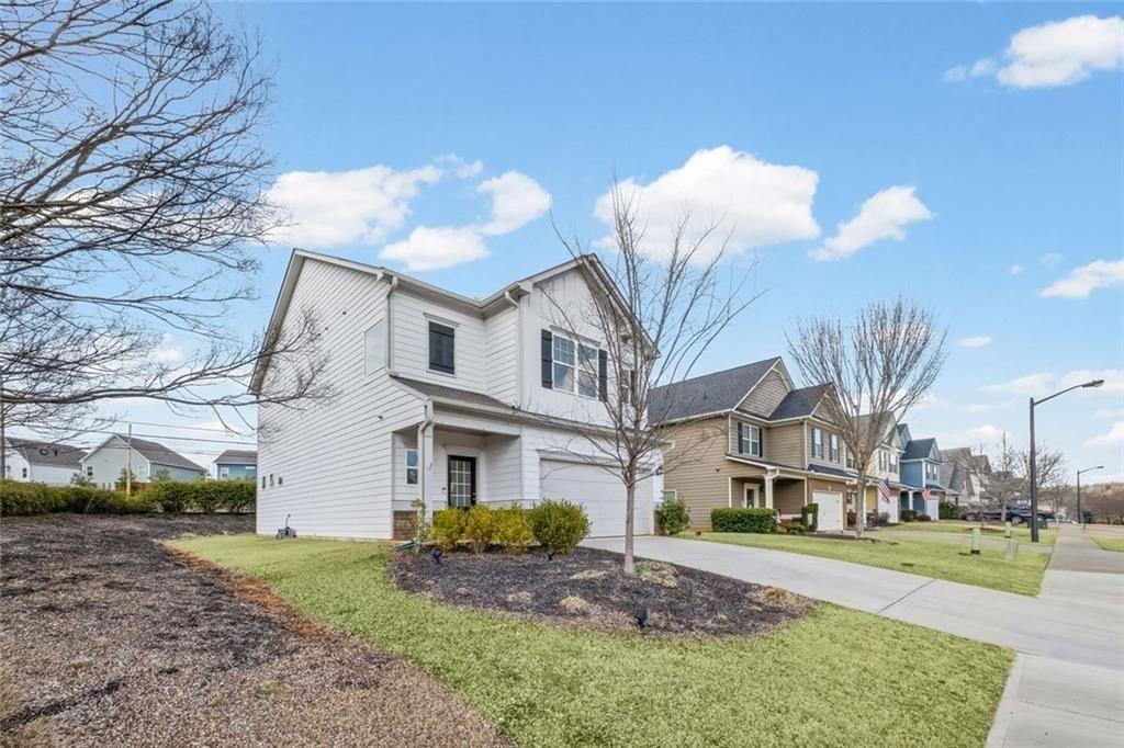 252 Renford Road Ball Ground, GA 30107 - Photo 2 of 36 a view of a white house next to a yard with big trees