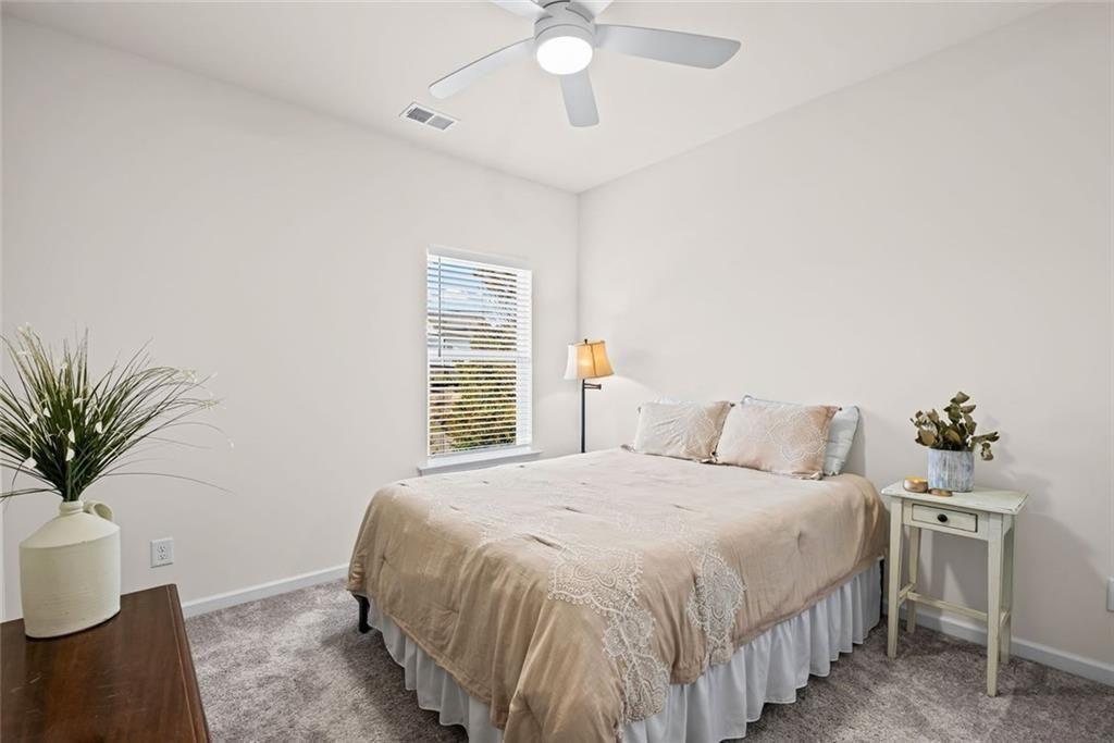 252 Renford Road Ball Ground, GA 30107 - Photo 21 of 36 a bedroom with a large bed and a chandelier