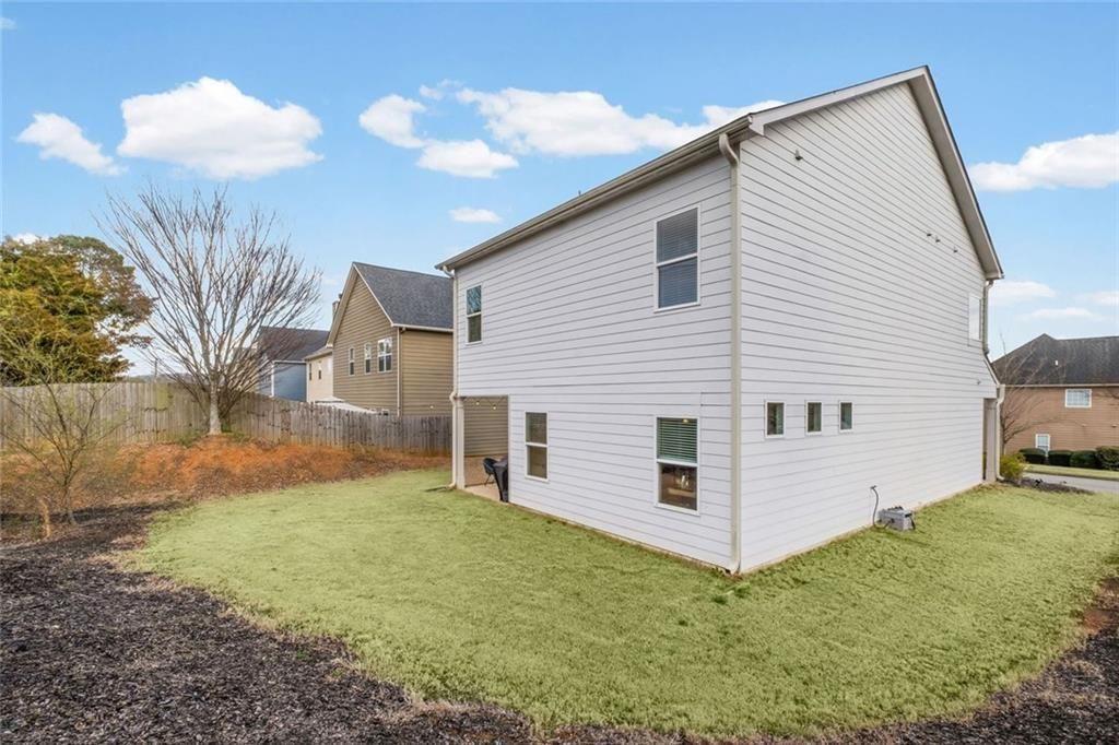252 Renford Road Ball Ground, GA 30107 - Photo 32 of 36 a view of a white house with yard and a large tree center with potted plants