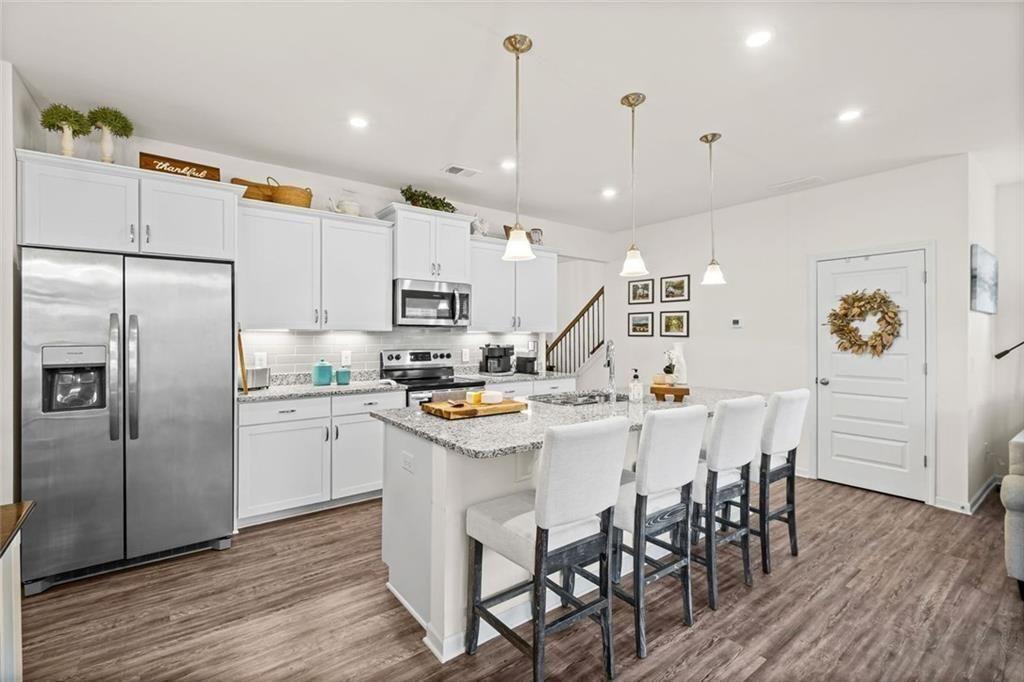 252 Renford Road Ball Ground, GA 30107 - Photo 6 of 36 a kitchen with kitchen island a white counter top space cabinets and stainless steel appliances