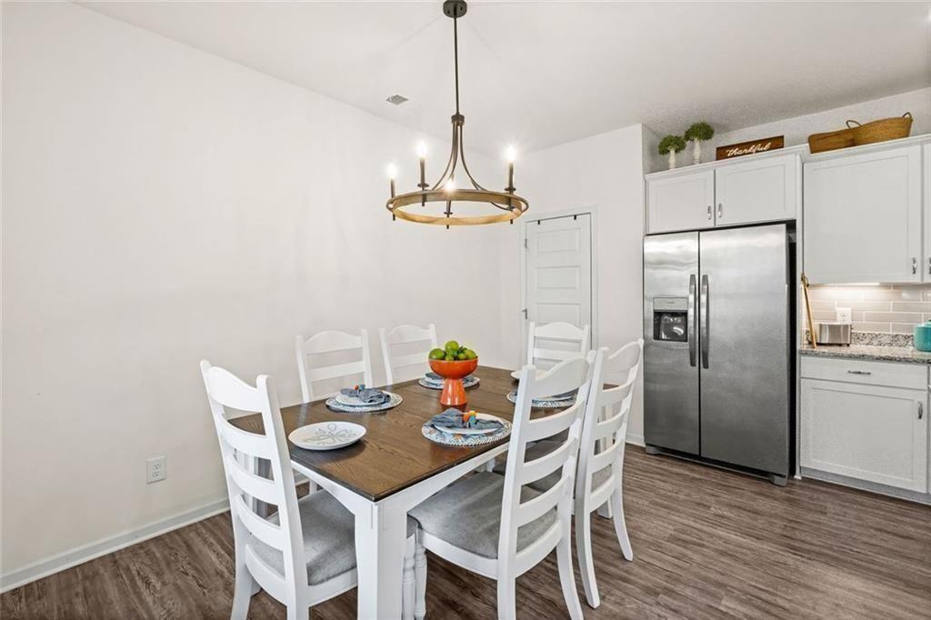 252 Renford Road Ball Ground, GA 30107 - Photo 7 of 36 a dining room with furniture a chandelier and wooden floor