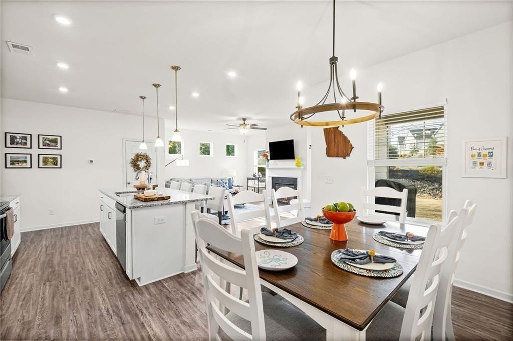 252 Renford Road Ball Ground, GA 30107 - Photo 8 of 36 a kitchen with stainless steel appliances kitchen island granite countertop a stove a sink a refrigerator and white cabinets with wooden floor