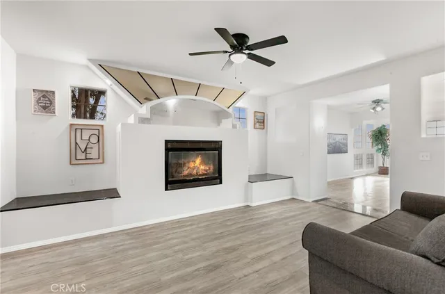 a view of an empty room with wooden floor and windows