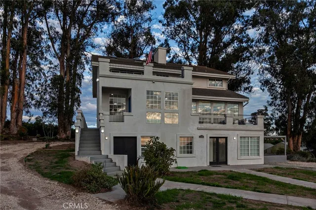 front view of a white house with a tree