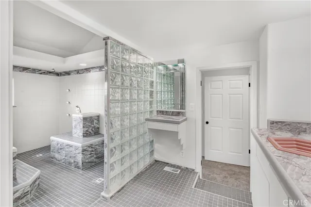 a bathroom with a granite countertop sink and a mirror
