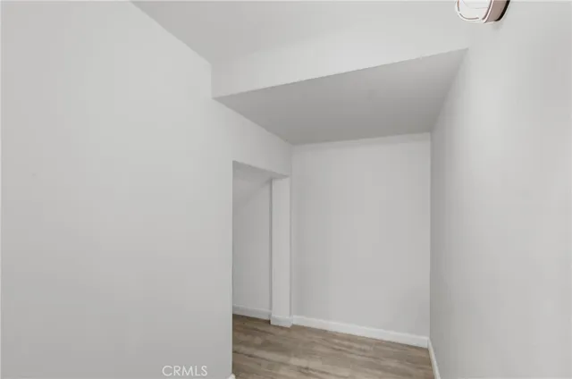 a view of a room with wooden floor and white walls