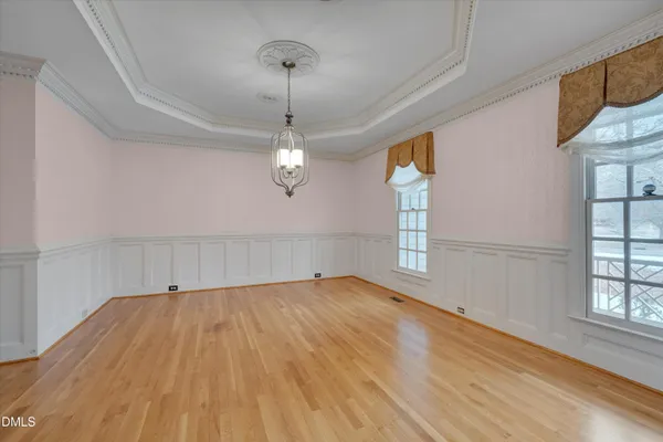 a view of a room with wooden floor ceiling fan and windows