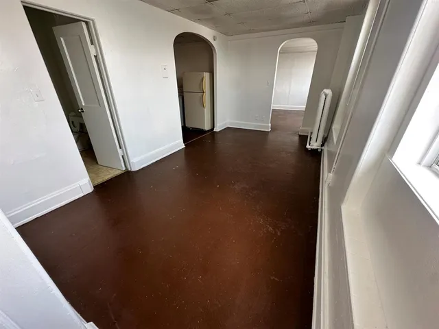 an empty room with wooden floor and seating