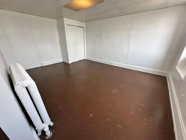 an empty room with wooden floor and seating